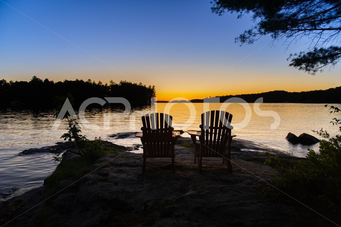 Adirondack chairs facing water 2868