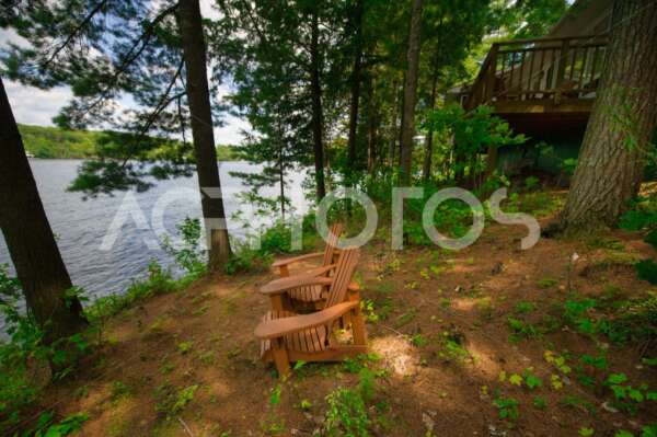 Adirondack chairs near a calm lake 2748