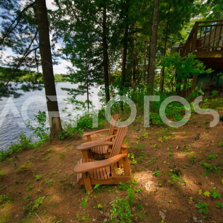 Adirondack chairs near a calm lake - GettaPix