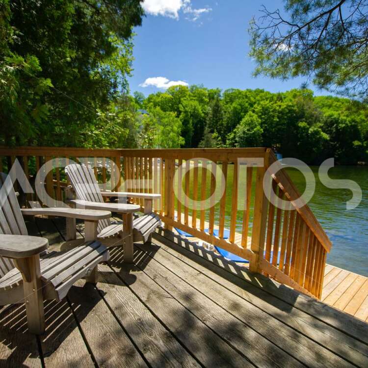 Adirondack chairs sitting on a cottage wooden deck 2856