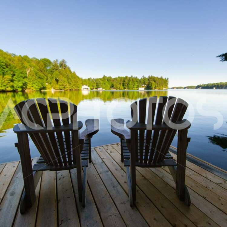 Adirondack chairs sitting on a wooden dock 2892