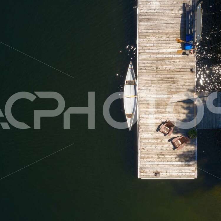 Drone aerial view of two Adirondack chairs on a wooden dock 2994