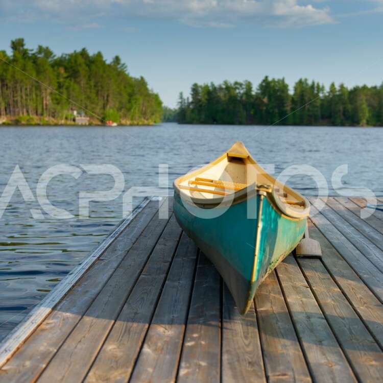 Green canoe rest on a lake wooden pier 2486