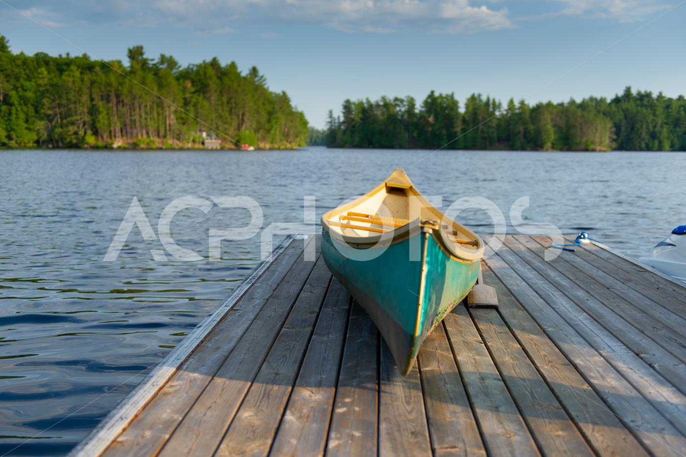 Green canoe rest on a lake wooden pier 2486