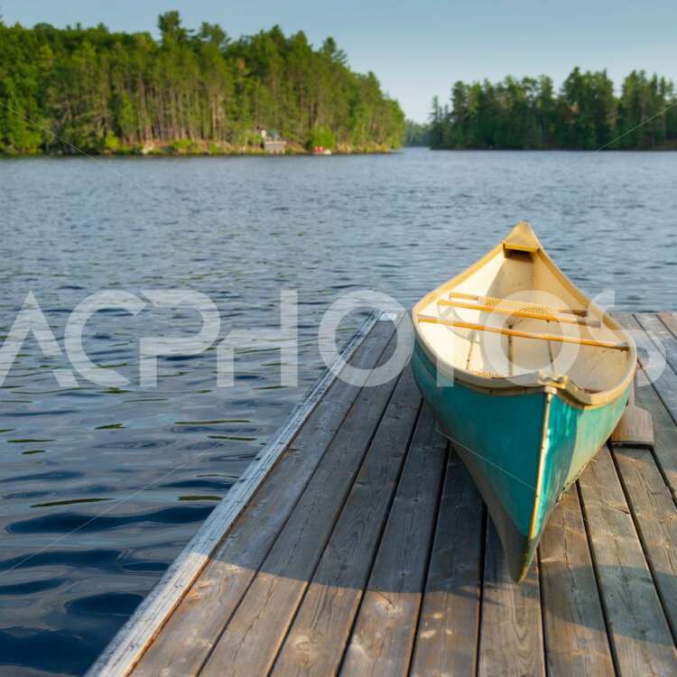 Green canoe sitting on a lake wooden pier 2492