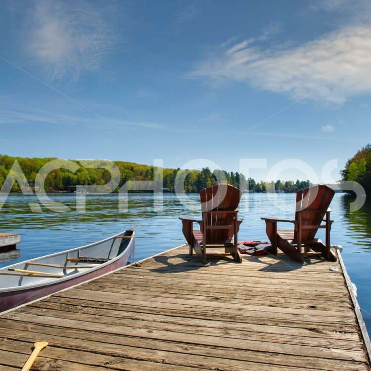 Muskoka chairs sitting on a wood dock 2970