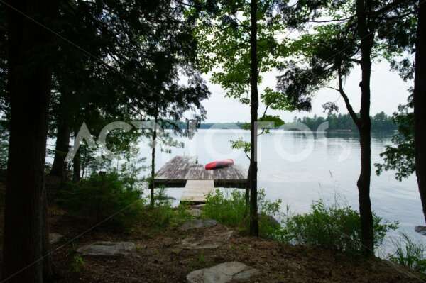 Muskoka shoreline lake view with a wooden dock - GettaPix