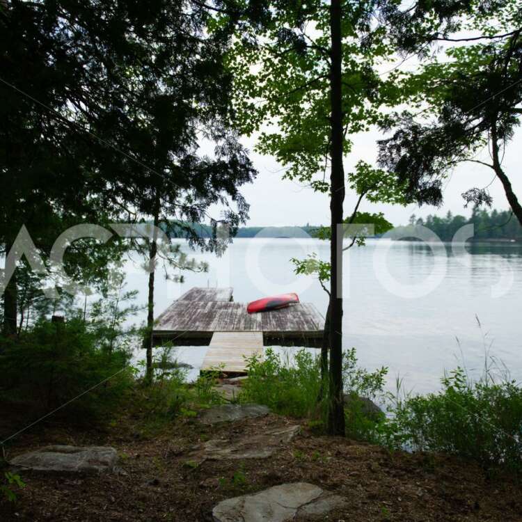 Muskoka shoreline lake view with a wooden dock - GettaPix