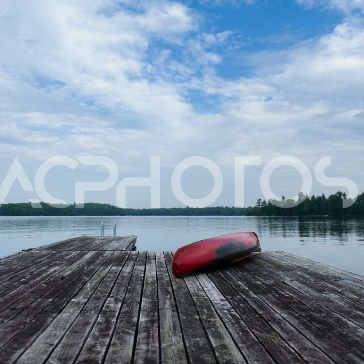 Old red kayak rest on a lake wooden pier 2516