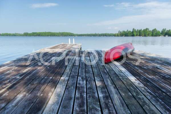 Red kayak rest on a lake wooden pier 2528