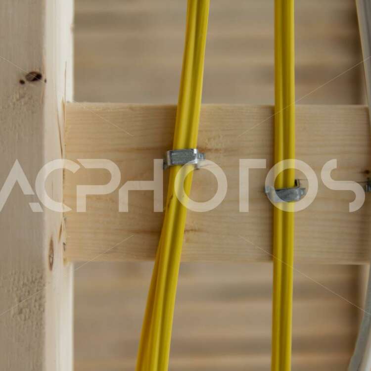 Close up of three electrical wires stapled to a frame 3099