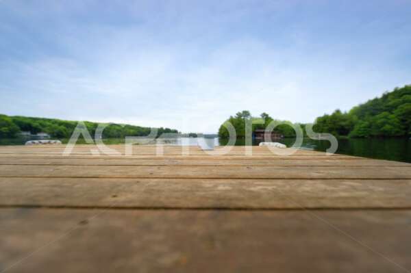 Metal coffee cup on a wooden dock facing a lake - Get A Pix