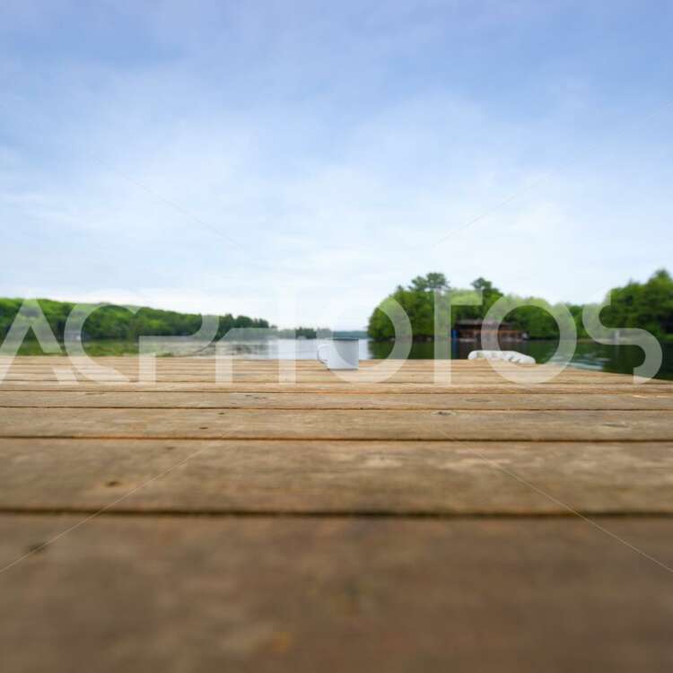 Metal coffee cup on a wooden dock facing a lake - Get A Pix
