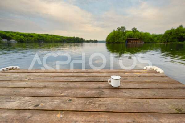 Metal coffee cup on wooden dock
