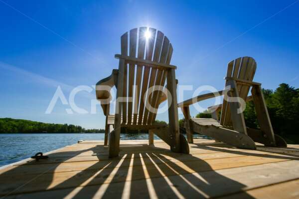 Summer Sunlight Creating Long Shadows on Two Adirondack Chairs - GettaPix