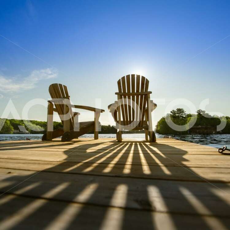 Summer Sunlight Creating Long Shadows on Two Adirondack Chairs - GettaPix