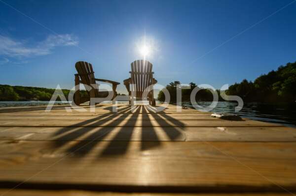 Summer Sunlight Creating Long Shadows on Two Adirondack Chairs 3360