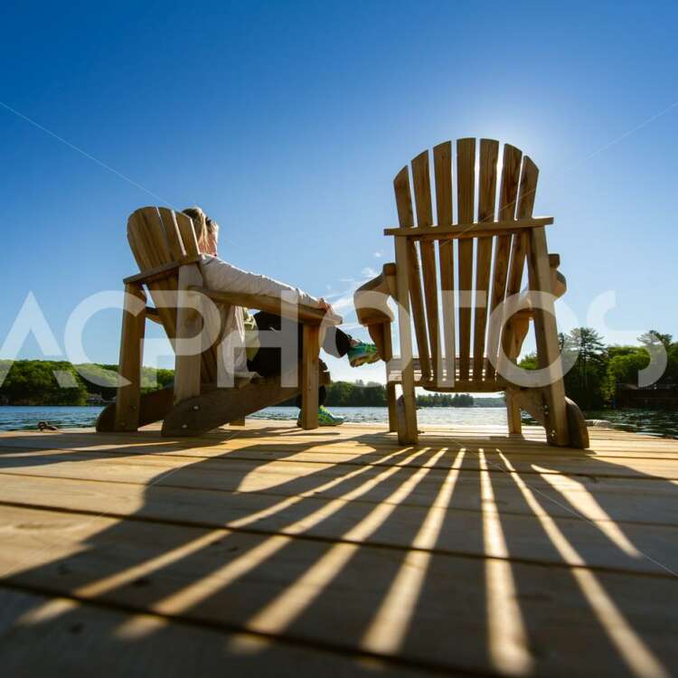 Sunrise on Two Empty Adirondack Chairs - GettaPix