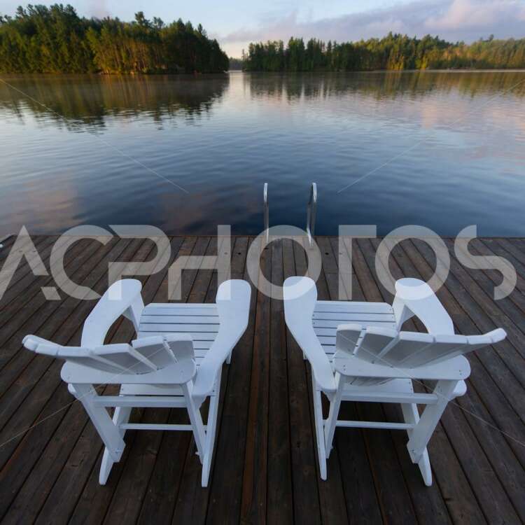 White Adirondack Chairs Sitting on a Wooden Pier - GettaPix