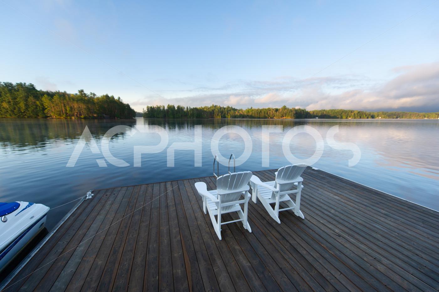 White Adirondack Chairs on a Wooden Dock on a Lake 3488