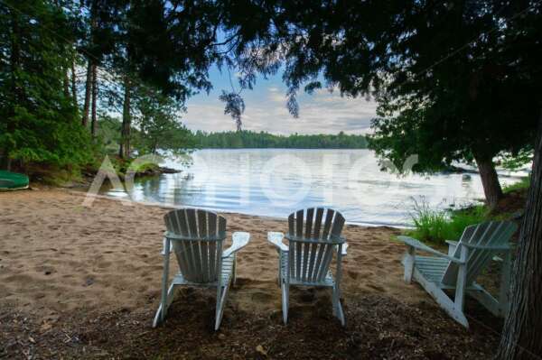 White Adirondack chairs on a beach - GettaPix