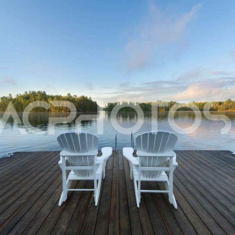 White Adirondack chairs on a pier - GettaPix