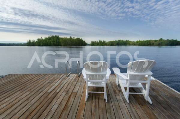 White Adirondack chairs on a wooden dock - GettaPix