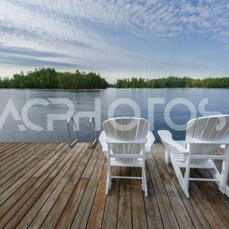 White Adirondack chairs on a wooden dock 3526