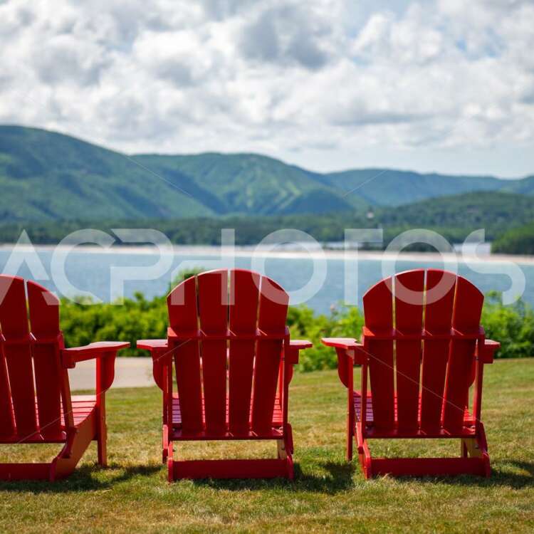 Red Adirondack chairs facing the scenic view of the beach in Ingonish - GettaPix