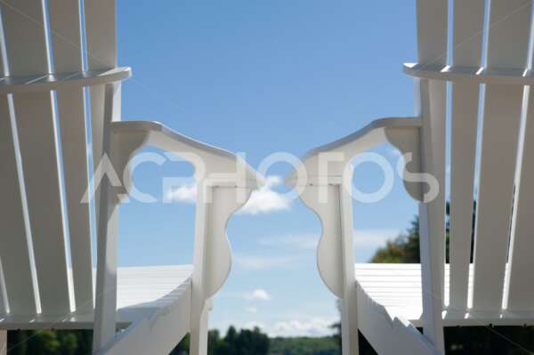 Low angle close up of two white Adirondack chairs - GettaPix
