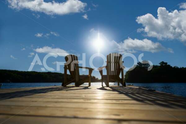 Sunrise on two empty Adirondack chairs - GettaPix