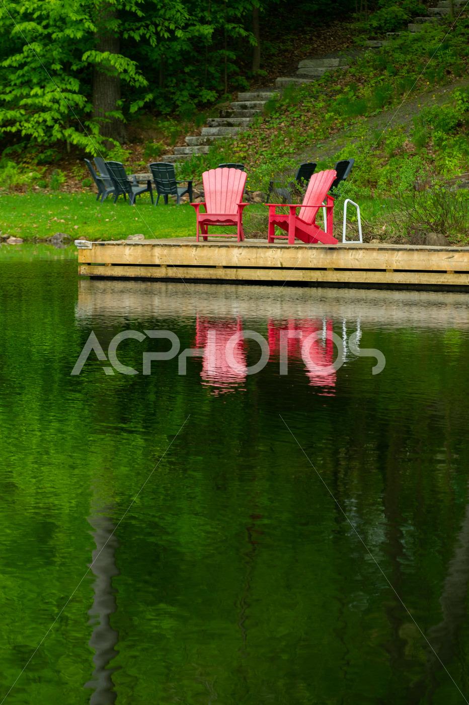Two Adirondack chairs on a wooden dock - GettaPix