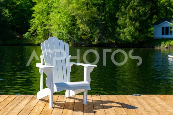 White Adirondack chair sitting on a wooden dock - GettaPix